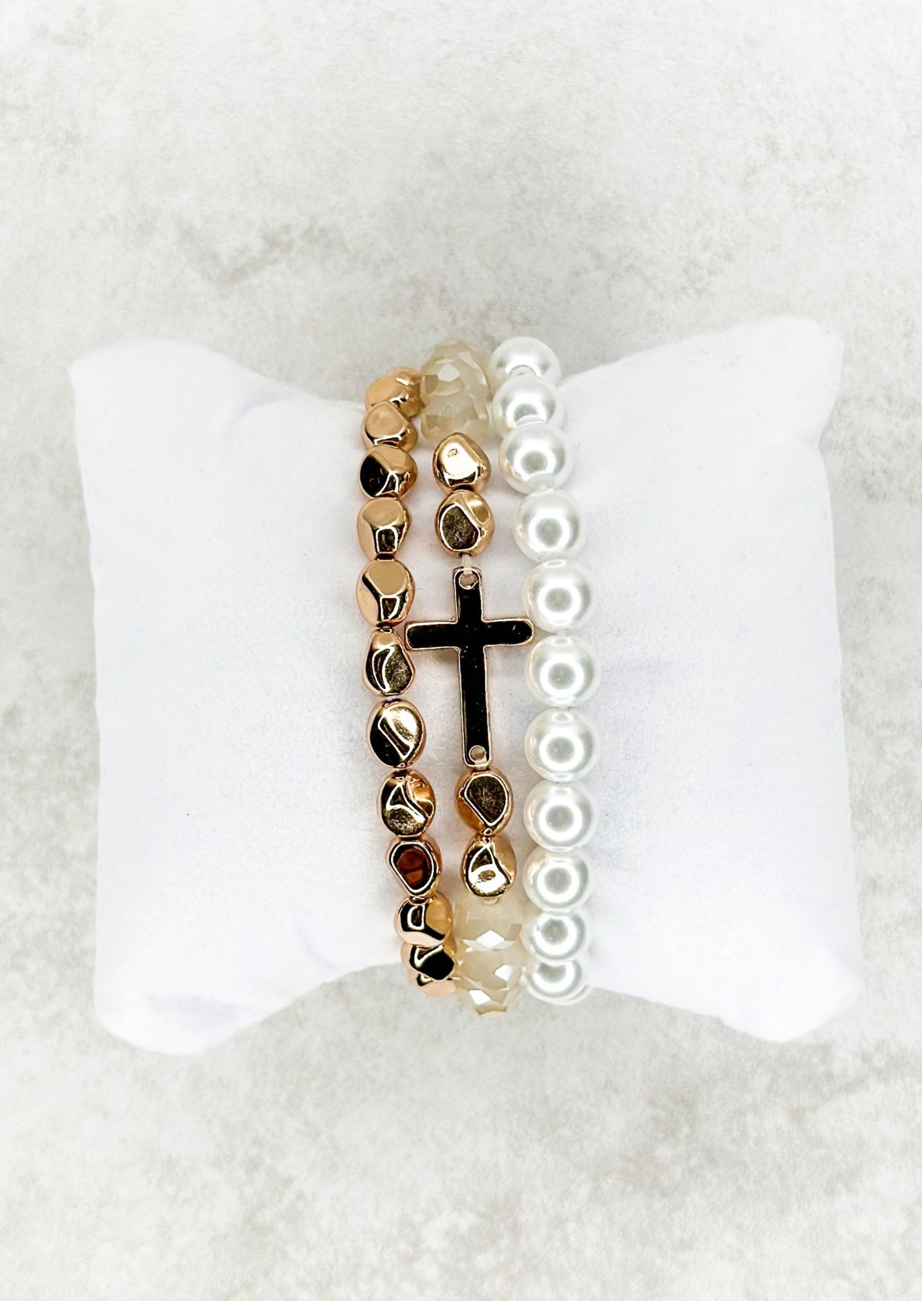 3 strand beaded stretch bracelets - one gold, one white pearl looking - one champagne colored with gold and a single gold cross