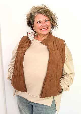 Reversible puffer vest with red and pink floral on one side, brown corduroy on the other.  Pockets on both sides, collared with zipper closure.