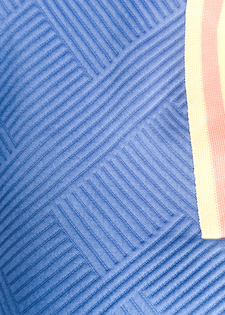Close up of blue textured dress with pink and white contrast.  Short sleeves and pockets
