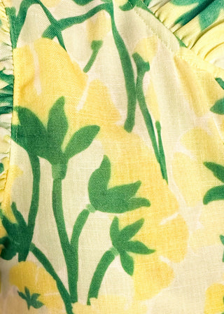 close up of women’s flowy maxi dress with green and yellow floral pattern and ruffle sleeve detail.
