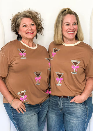 Mocha top featuring sparkling sequin cocktail glasses with pink bows and cream neckline.