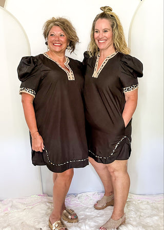Black puff sleeve knee length dress.  Leopard piping detail on sleeves, v-neck, and at the bottom of the dress. Short sleeve.