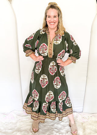 Palm green maxi dress with colorful floral medallion print, orange embroidered trim at neckline, and smocked cuffs