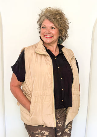 Beige puffer zip up vest with sides that tie and pockets