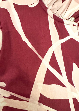 close up of tiered midi dress in Burgundy abstract floral print.