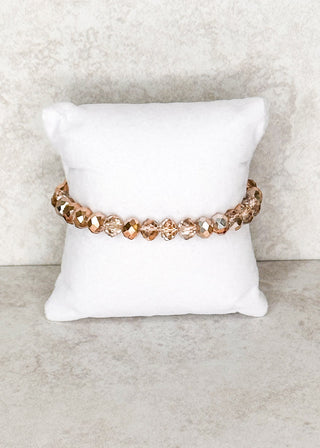 Copper beaded bracelet displayed on a stand 