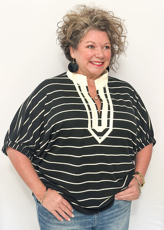 Black and cream striped dolman top with cream trim and flowy short sleeves.