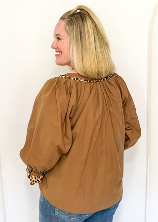 Mocha brown long-sleeve blouse with leopard print trim on neckline and cuffs.