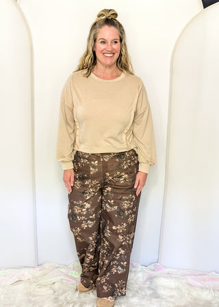 brown wide leg pants with belt loops, zipper and button closure, front and back pockets, creamy floral pattern throughout