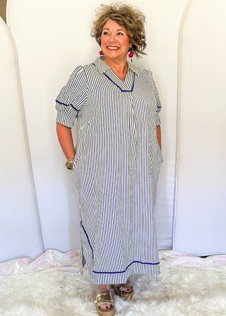 Blue and cream striped midi dress with short sleeves, split V-neckline with contrast trim, pockets, and a relaxed fit.