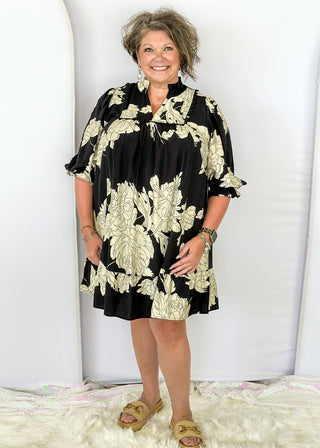 Black knee length dress with large white florals. 3/4 length flowy sleeve. Black scallop detail on chest. Lined 