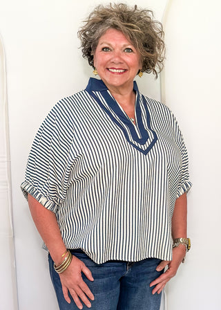 Model wearing an indigo-colored Entro dolman striped top with contrast trim, styled in a relaxed, casual fit.