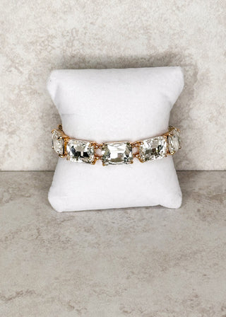 Clear gemstone bracelet displayed on a stand 
