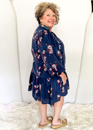 Floral navy dress featuring v-neckline, burgundy piping, and puff sleeves