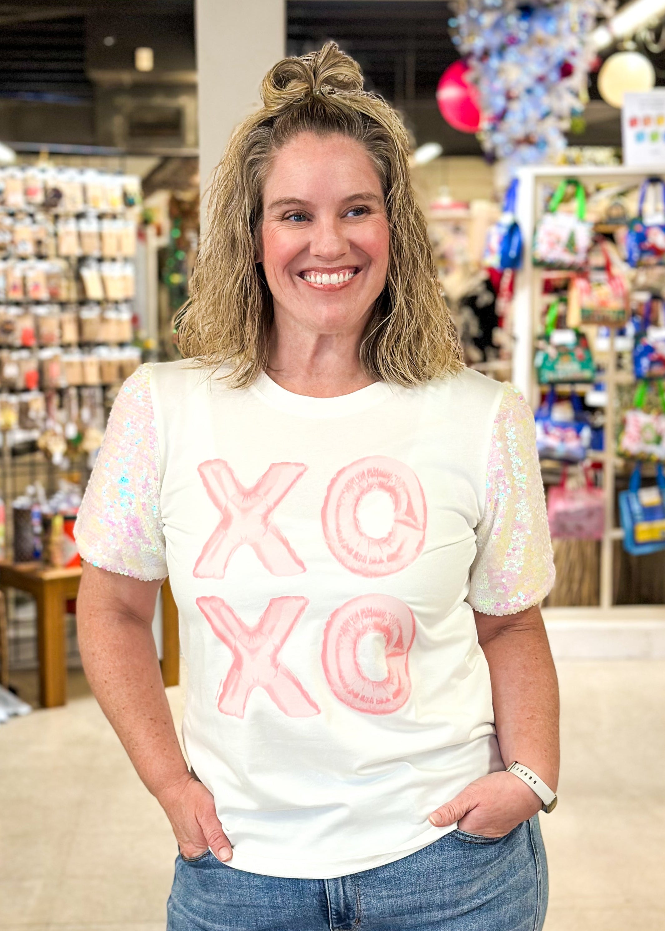 white short sequin sleeve top with XOXO in a light pink on the front - iridescent sequins on sleeves