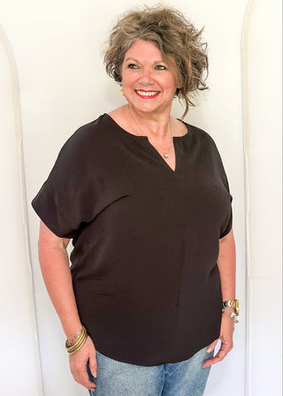 Solid black textured blouse with a V-notch neckline, short sleeves
