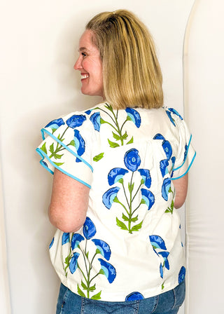 white top with oversized blue flower pattern and short sleeves