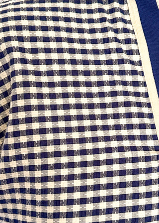 Navy check pattern blouse with contrast white stitching, short dolman sleeves, relaxed shape, and v-split neckline.