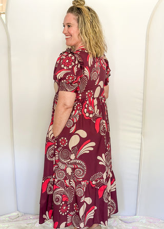Plum floral maxi dress with short sleeves and v-neck. Collar has contrast piping in light brown and coral. 