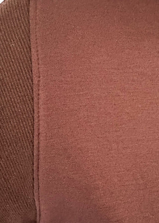 Close-up of a brown short-sleeve t-shirt showing the ribbed knit texture of the sleeve and the smooth fabric of the body.