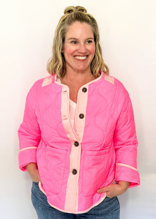 Bright pink quilted jacket with light pink contrast trim, long sleeves, patch pockets, and button-front closure