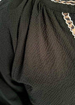 Textured black blouse with leopard lace detail on v-neckline and cuffs.