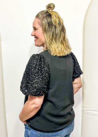 black top featuring sparkly sequin puff sleeves and a relaxed, flowy body.