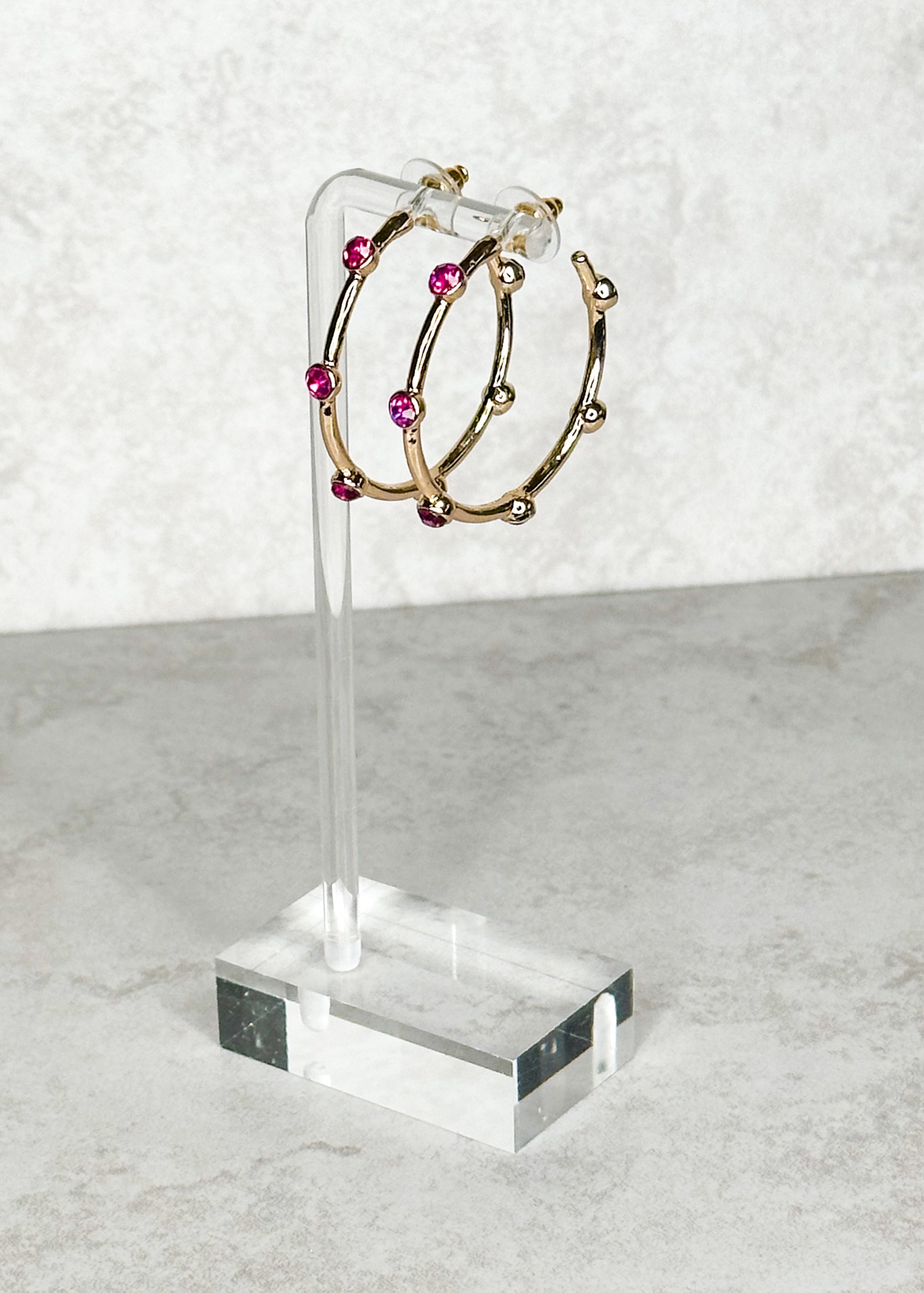 Gold with magenta colored jewels, open hoop, post back earrings.