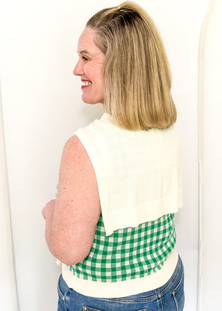 Sleeveless green checkered sweater with faux wrap in cream.