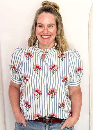 Short sleeve button up top with blue stripes and embroidered floral bundles in red and pink. 