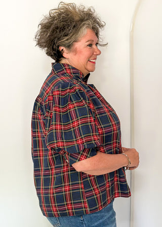 side view of woman wearing a short sleeve button up top in Navy/Red plaid