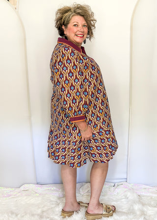 Wine-colored geometric print dress with collared neckline, tiered hem, and 3/4 sleeves.