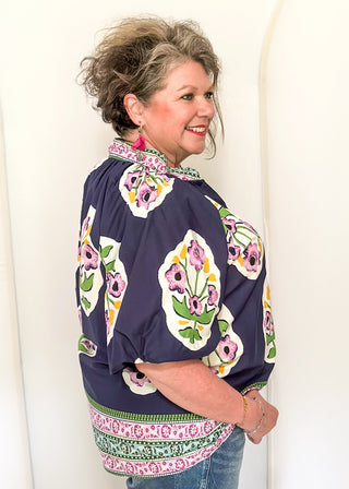 women’s floral blouse in navy with contrast neckline detail, and decorative hem