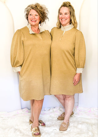 Long-sleeve textured neutral tan dress with a striped ruffle neckline, partial button front, and matching striped sleeve cuffs