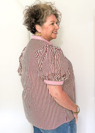 woman wearing burgundy stripe button up top.