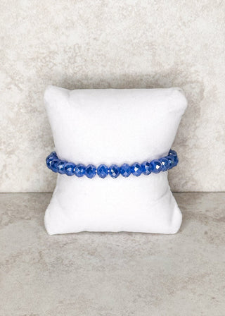Blue beaded bracelet displayed on a stand 