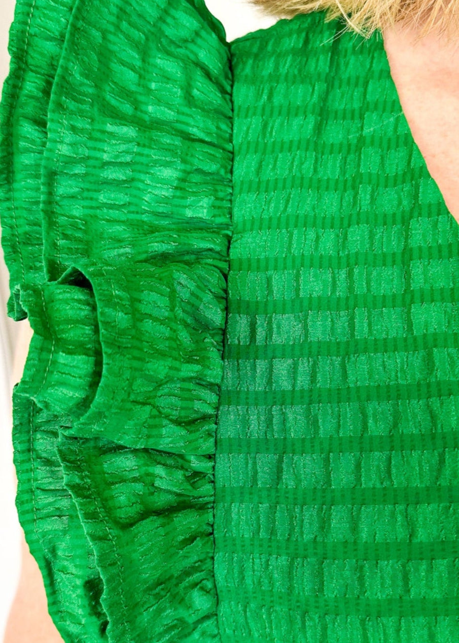 Flutter sleeve, V-neck tiered dress-ruffle detail at waist. Solid color in Kelly Green with seersucker like texture. 