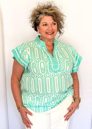Patterned short-sleeve top in mint with contrast trim with scallops, v-neckline.