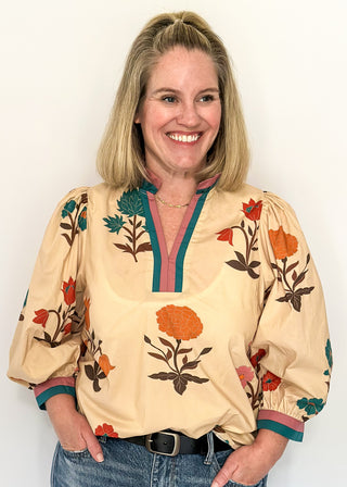 Ecru floral blouse with colorful flowers, contrast turquoise and rose trim, and ruffled neckline