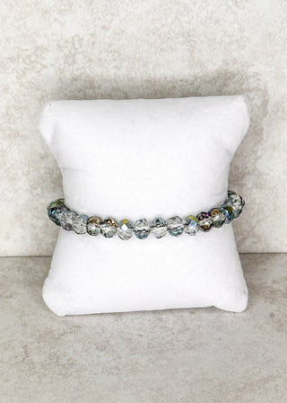 Smoky iridescent beaded bracelet displayed on a stand 