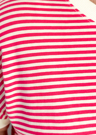 Close-up of a red and white striped shirt with a brand logo.