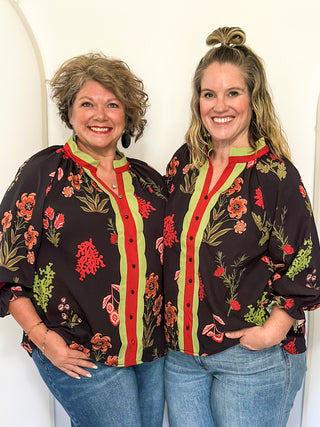 black button up long sleeve top with red flowers and greenery - red and green scalloped stripe detail along collar and down front 