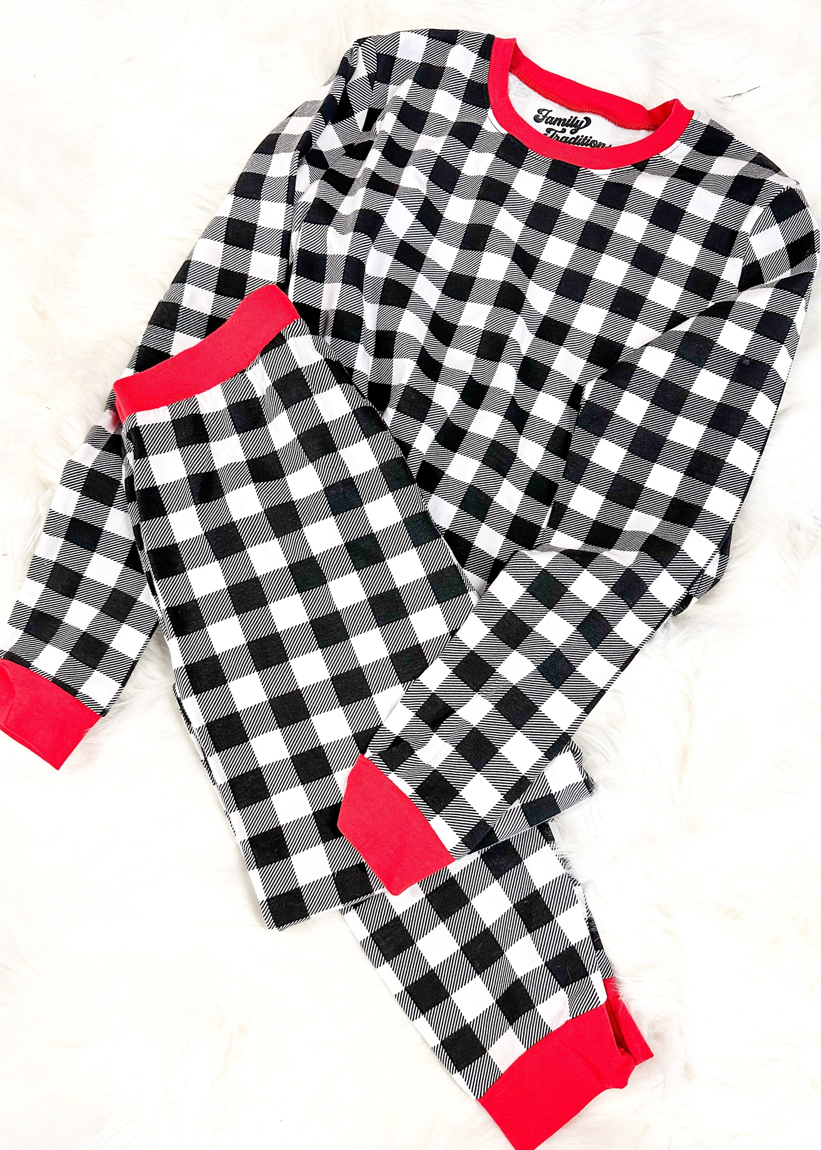 black and white checkered pajama jogger set with red band around collar, waist, cuff and bottom of the joggers