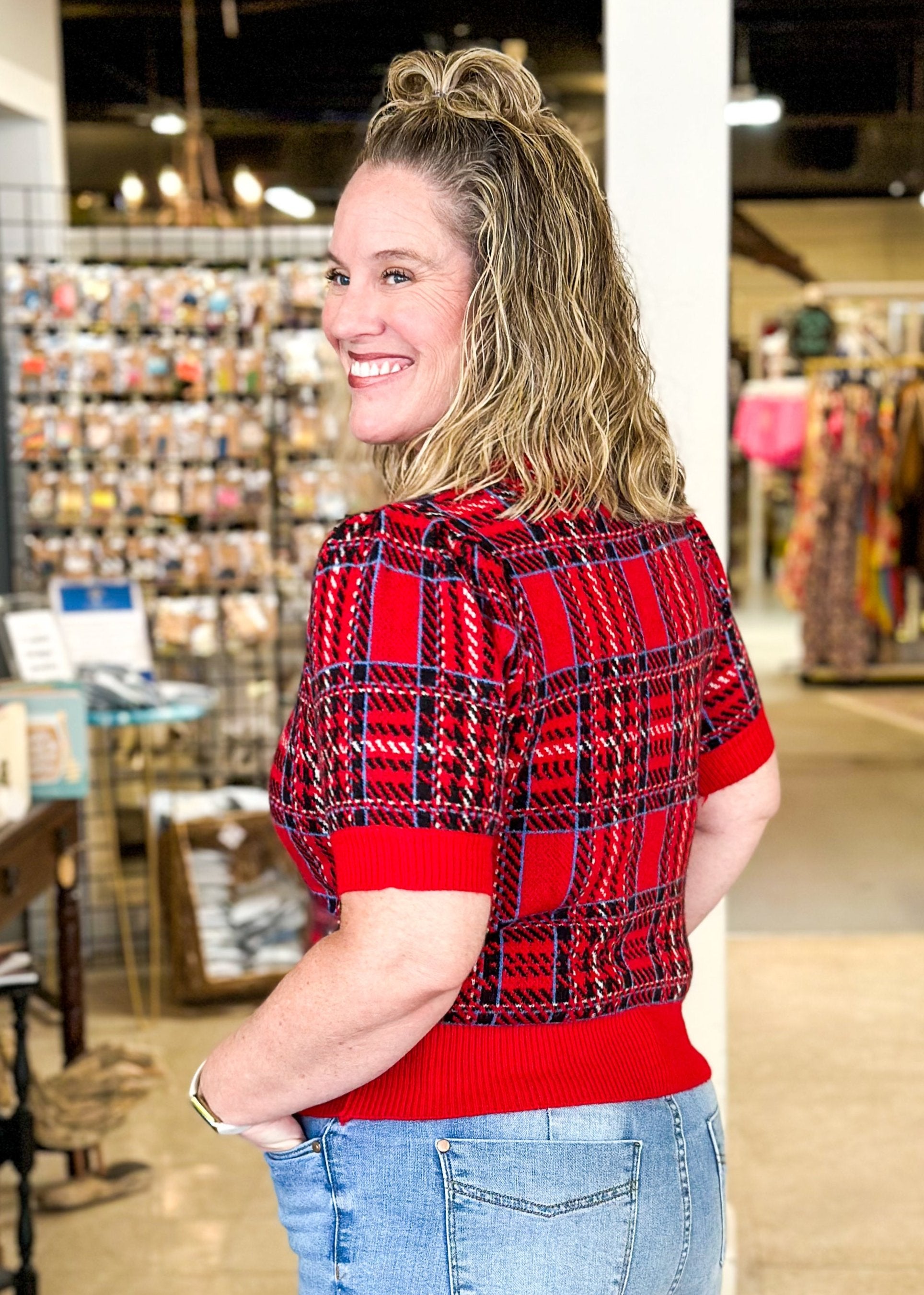 Red plaid short puff sleeve sweater with black and blue plaid and sold red bands around cuff, hem and neck