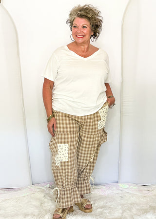 woman modeling gingham bloomer pants with patches and pockets.