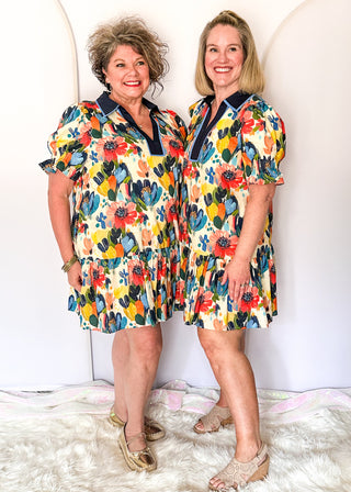 Vibrant watercolor floral dress with short sleeves, lined fabric, tiered hem, and pockets