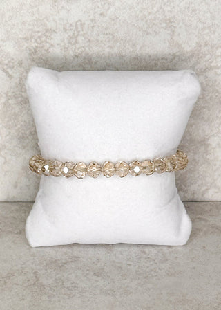 Champagne beaded bracelet displayed on a stand 