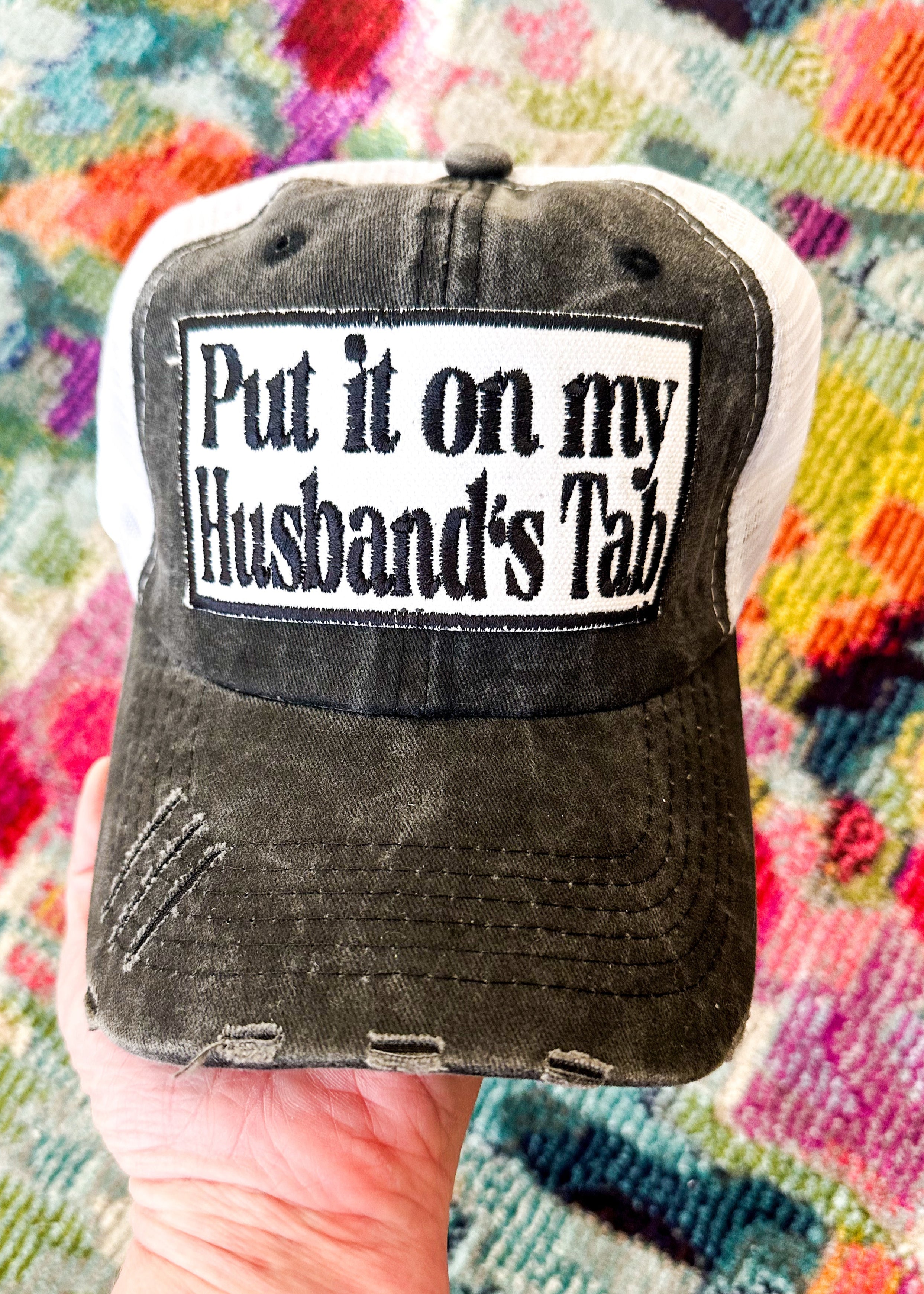 Put it on my husband's tab patch in black  Distressed black front with white mesh back. Velcro back