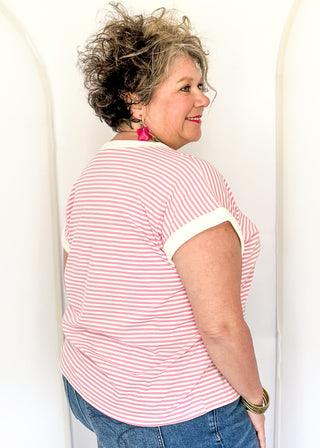 Pink and white stripe short sleeve top with white contrast banding on the collar and sleeves. 