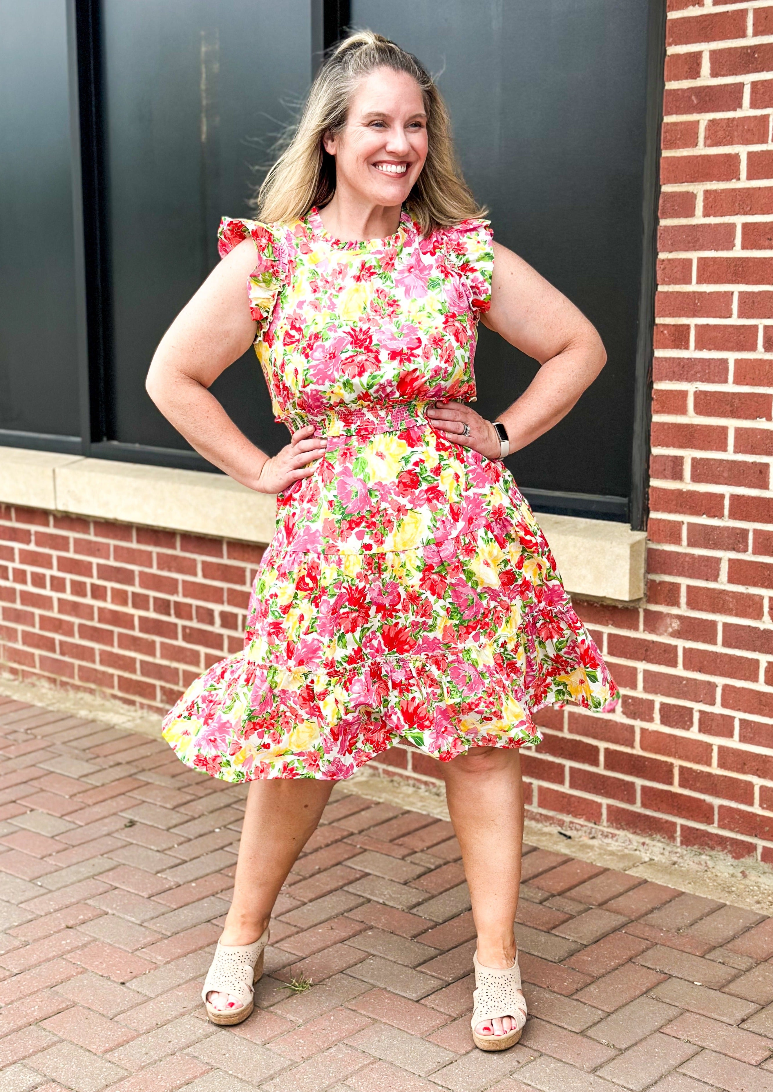 bright floral print smocked waist dress with pockets, ruffle sleeve and neck and one around the bottom  - print colors are yellow, pinks, reds and some green